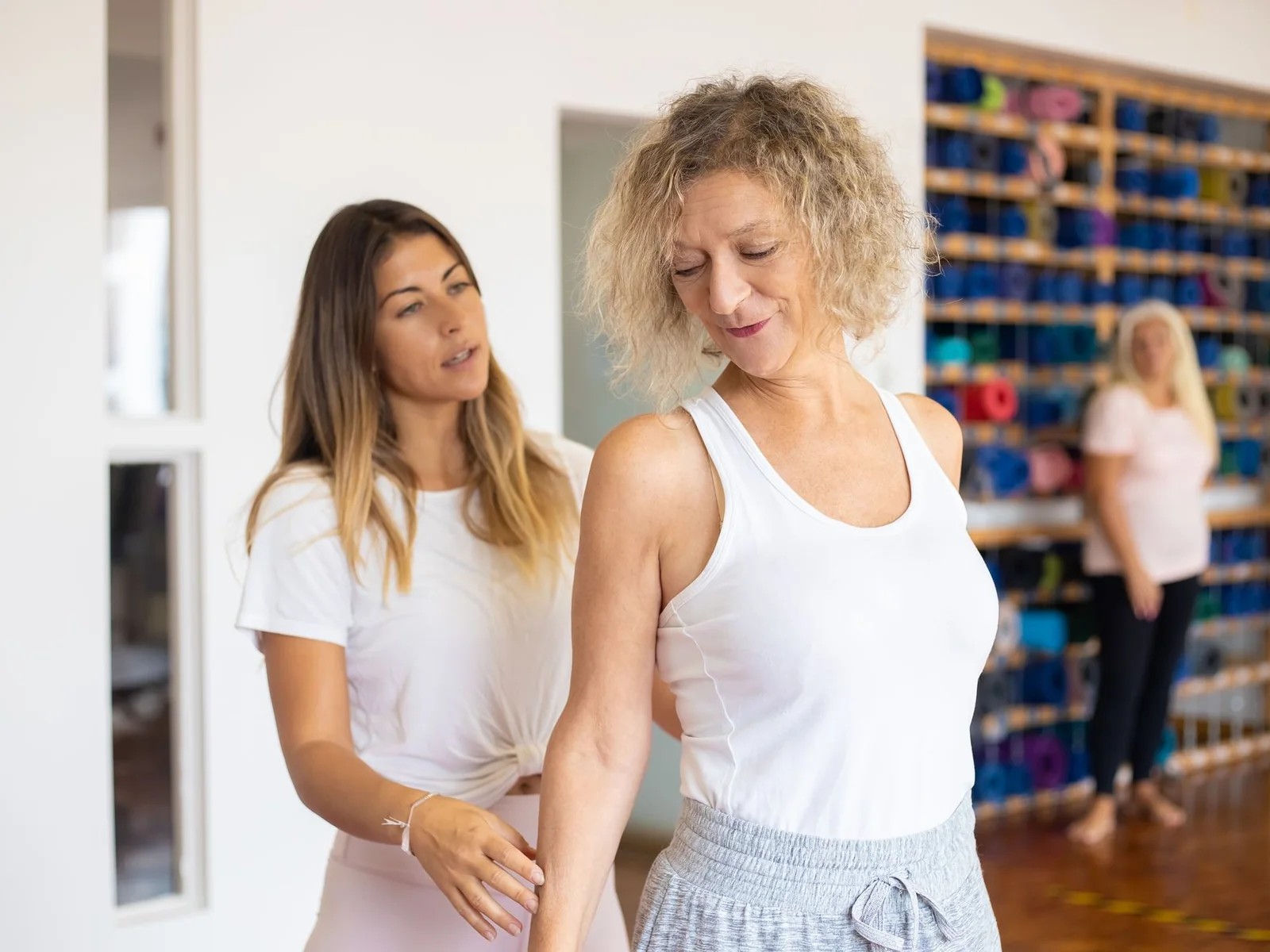 Fisioterapeuta acompanhando aluna durante exercício de Pilates